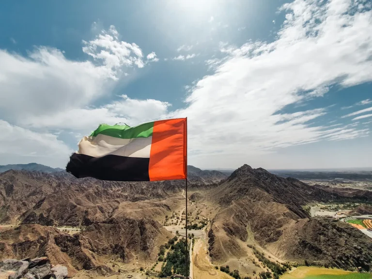 UAE flag with Fujairah mountain landscape